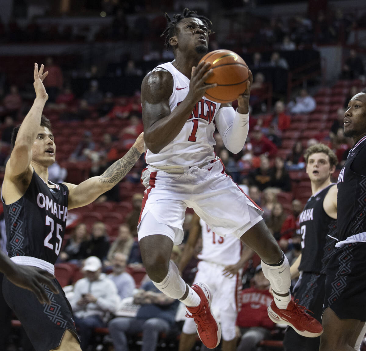 UNLV Rebels guard Michael Nuga (1) gets fouled while driving past Omaha Mavericks guard Felix L ...