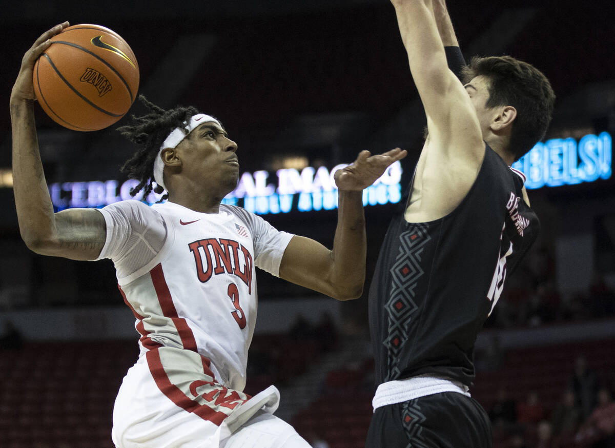 UNLV Rebels forward Donovan Williams (3) drives past Omaha Mavericks center Dylan Brougham (14) ...