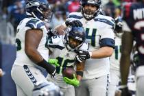 Seattle Seahawks wide receiver Tyler Lockett (16) celebrates with teammates after catching a pa ...