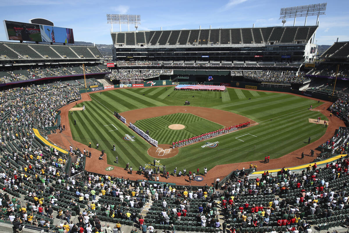 The Los Angeles Angels and Oakland Athletics stand for the national anthem at the Oakland Colis ...