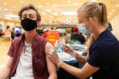 Jared Fessler, left, get’s his COVID-19 vaccination from Touro University Nevada physici ...