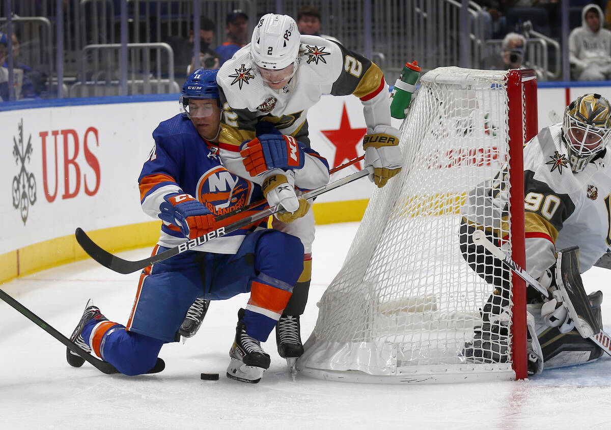 New York Islanders' Zach Parise (11) and Vegas Golden Knights' Zach Whitecloud (2) battle for t ...