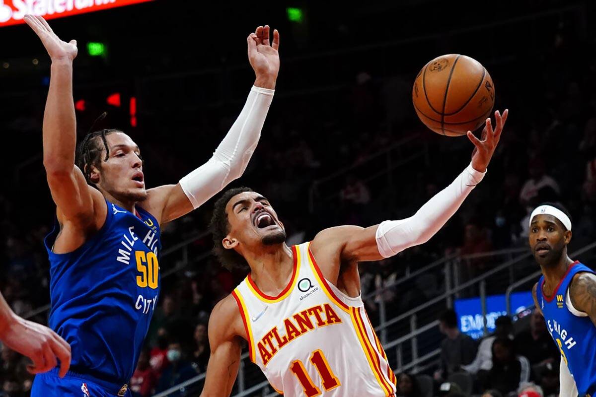 Atlanta Hawks guard Trae Young (11) goes past Denver Nuggets forward Aaron Gordon (50) during t ...