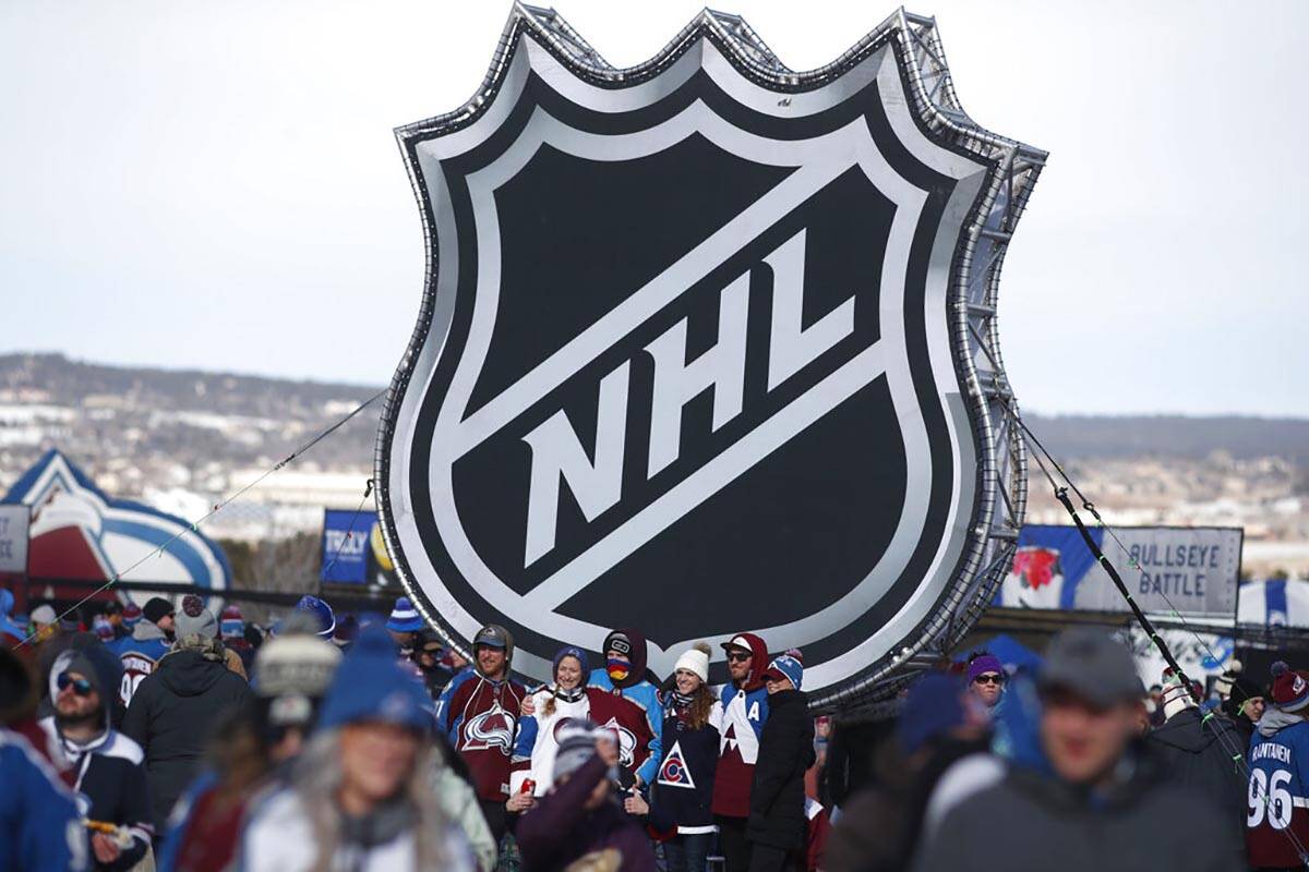 FILE - In this Feb. 15, 2020, file photo, fans pose below the NHL league logo at a display outs ...