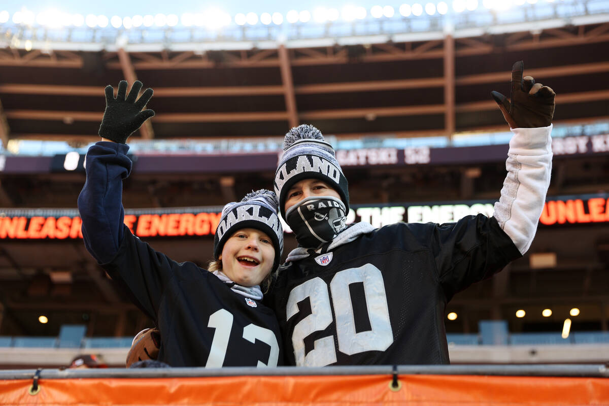 Gavin McCormack, left, 14, and his father Brent, pose for a picture before an NFL football game ...