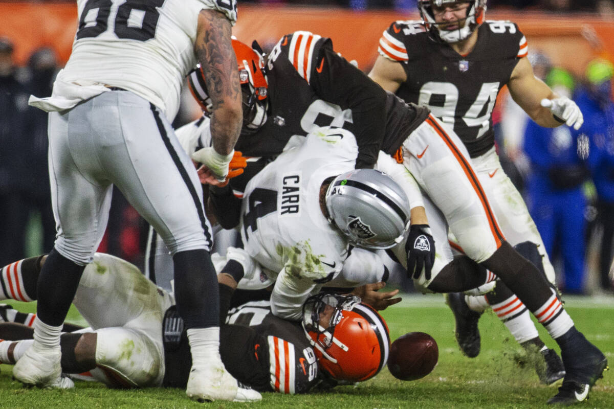 Raiders quarterback Derek Carr (4) fumbles the football as he is sacked by Cleveland Browns def ...