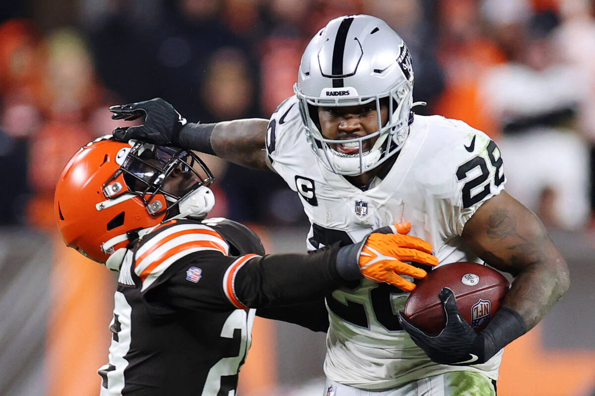 Raiders running back Josh Jacobs (28) stiff arms Cleveland Browns outside linebacker Jeremiah O ...