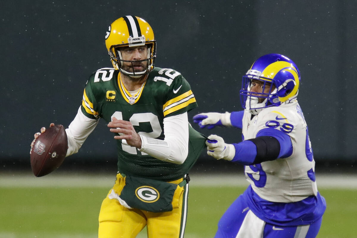 Green Bay Packers quarterback Aaron Rodgers (12) throws under pressure from Los Angeles Rams' A ...