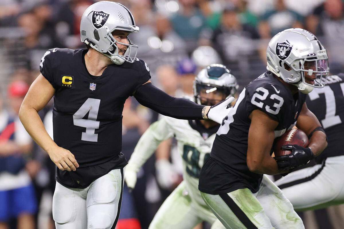 Raiders quarterback Derek Carr (4) hands off the ball to running back Kenyan Drake (23) for a r ...