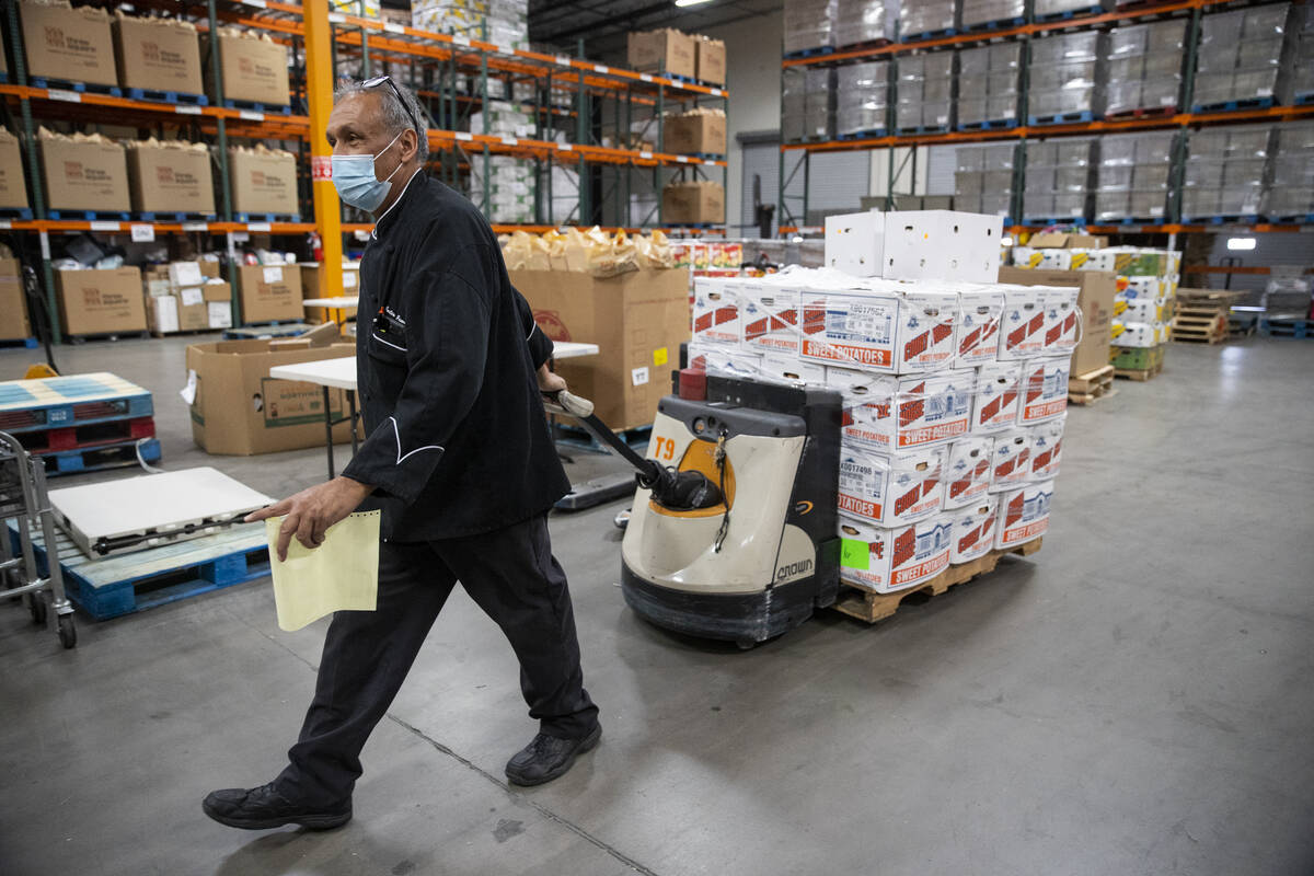 Volunteer Juli Jimenez moves a palette of food inside of the Three Square North Campus warehous ...