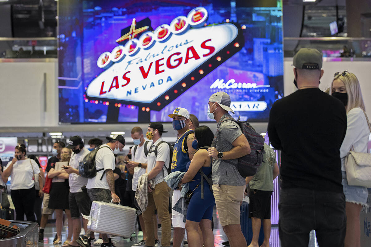 Arriving passengers wait for their luggage in the terminal 1 baggage claim area at McCarran Int ...