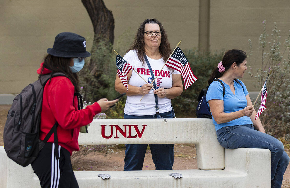 A UNLV student walks past protesters, including Susie K. of Las Vegas, right, as they protest a ...