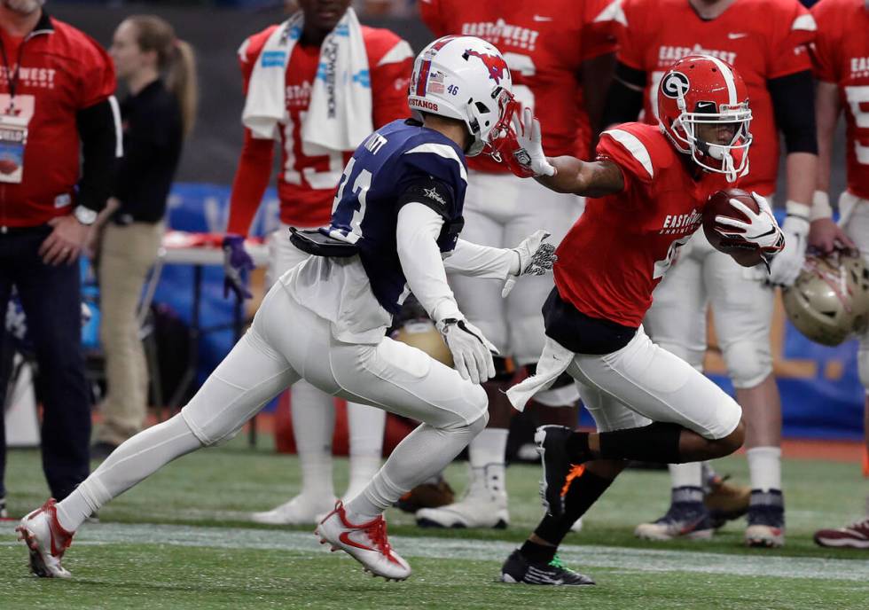 East Wide receiver Terry Godwin II (4), of Georgia, stiff arms West cornerback Jordan Wyatt (23 ...