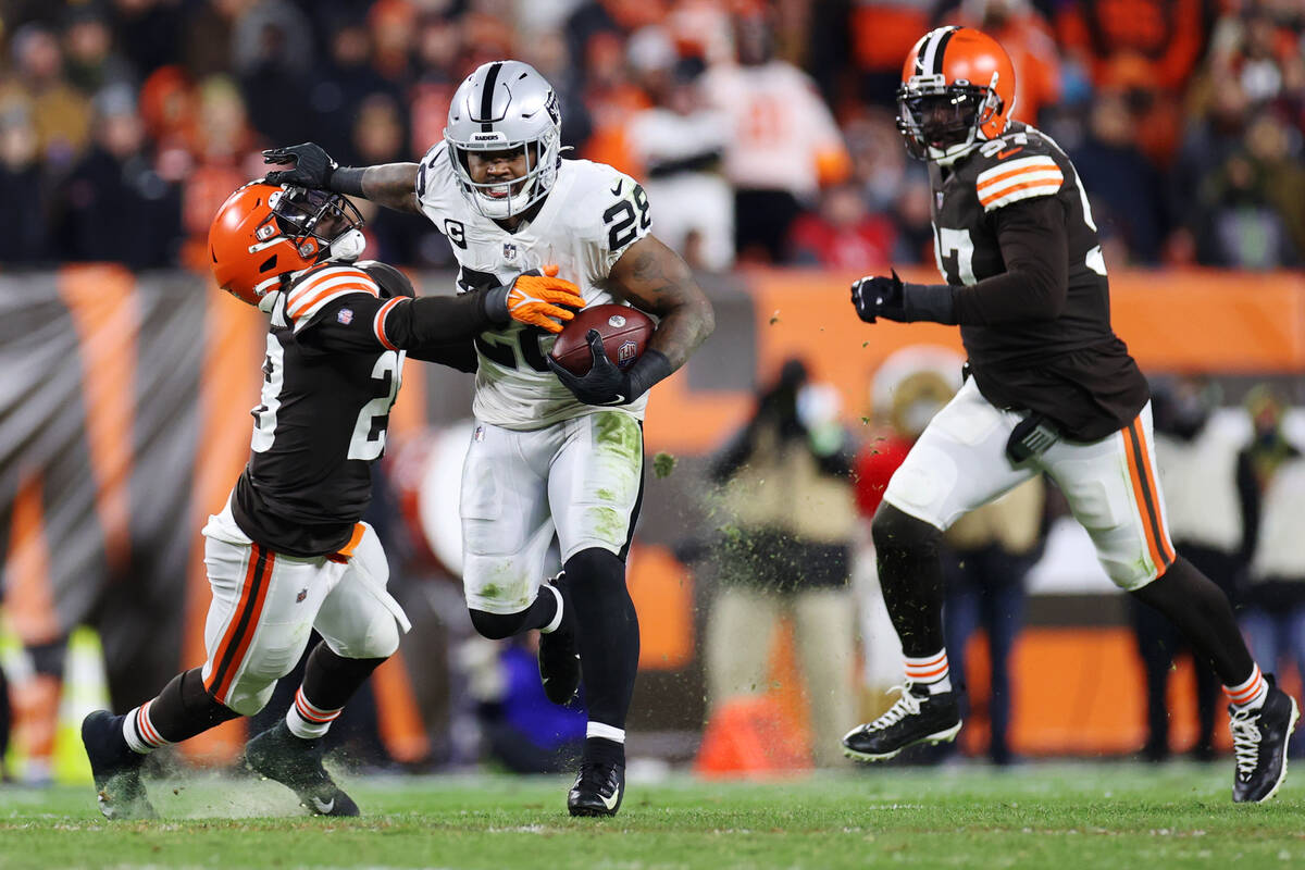 Raiders running back Josh Jacobs (28) stiff arms Cleveland Browns outside linebacker Jeremiah O ...