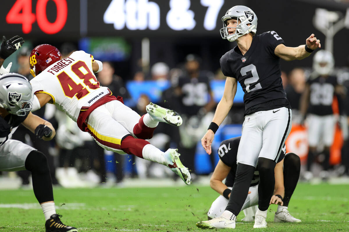 Raiders kicker Daniel Carlson (2) kicks the ball for a field goal under pressure from Washingto ...