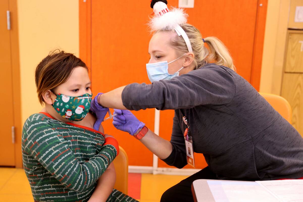 Bruce Resnikoff, 9, gets a COVID-19 vaccination from Allison Anderson during a free pop-up vacc ...