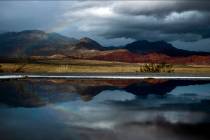 A rainbow appears above the valley floor at the Red Rock Canyon National Conservation Area and ...