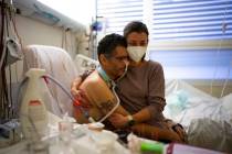 Amelie and Ludo Khayat hold each other during a visit at the COVID-19 intensive care unit of th ...