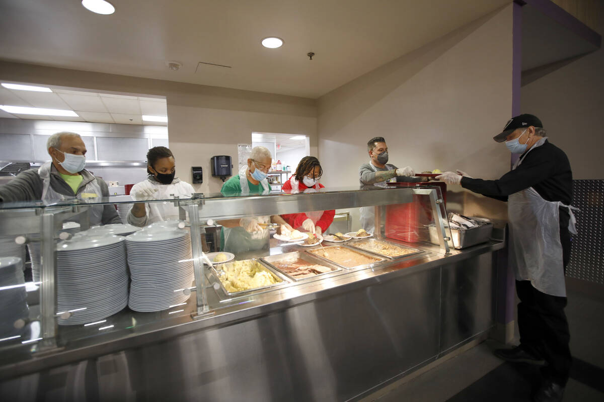 Volunteers prepare food to be served, Saturday, Dec. 25, 2021, during the annual Christmas Day ...