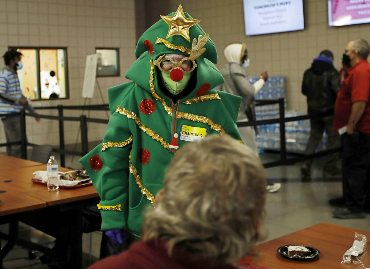 Volunteer Bette Kennedy of Las Vegas talks with a guest, Saturday, Dec. 25, 2021, as she gives ...