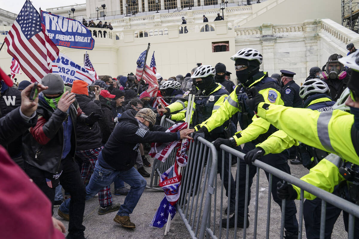 Trump supporters effort   to interruption  done  a constabulary  barrier, Wednesday, Jan. 6, 2021, astatine  the Capitol ...