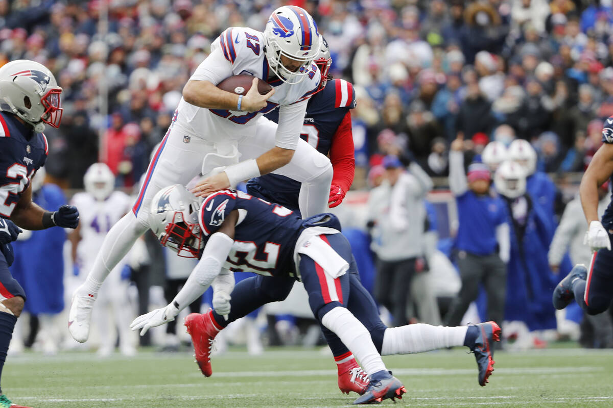 Buffalo Bills quarterback Josh Allen (17) leaps over New England Patriots free safety Devin McC ...