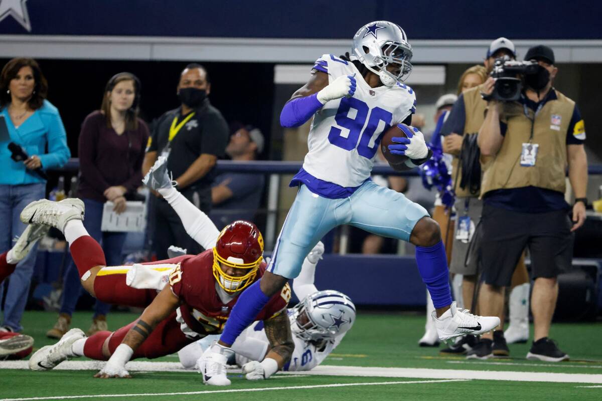 Dallas Cowboys defensive end Demarcus Lawrence (90) breaks tackles on the way to the end zone f ...