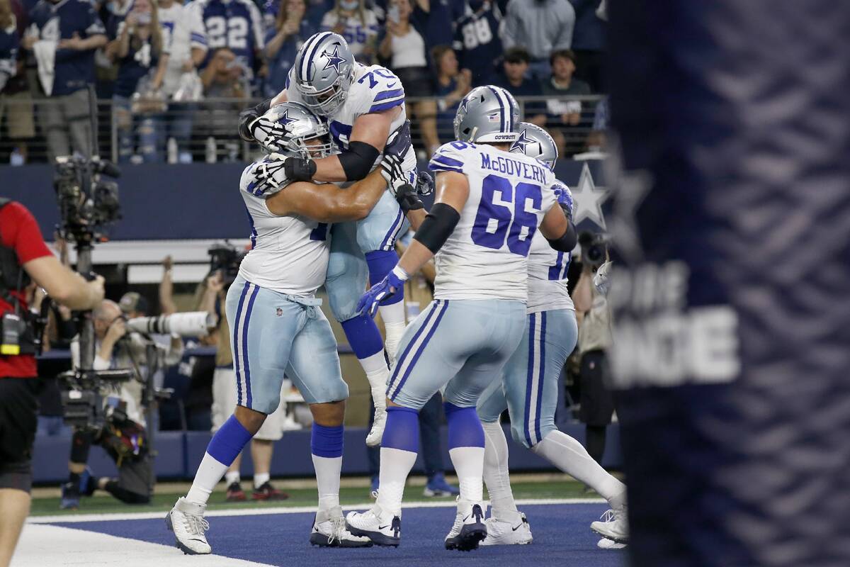 Dallas Cowboys' Terence Steele, left, Zack Martin (70), Connor McGovern (66) and others celebra ...