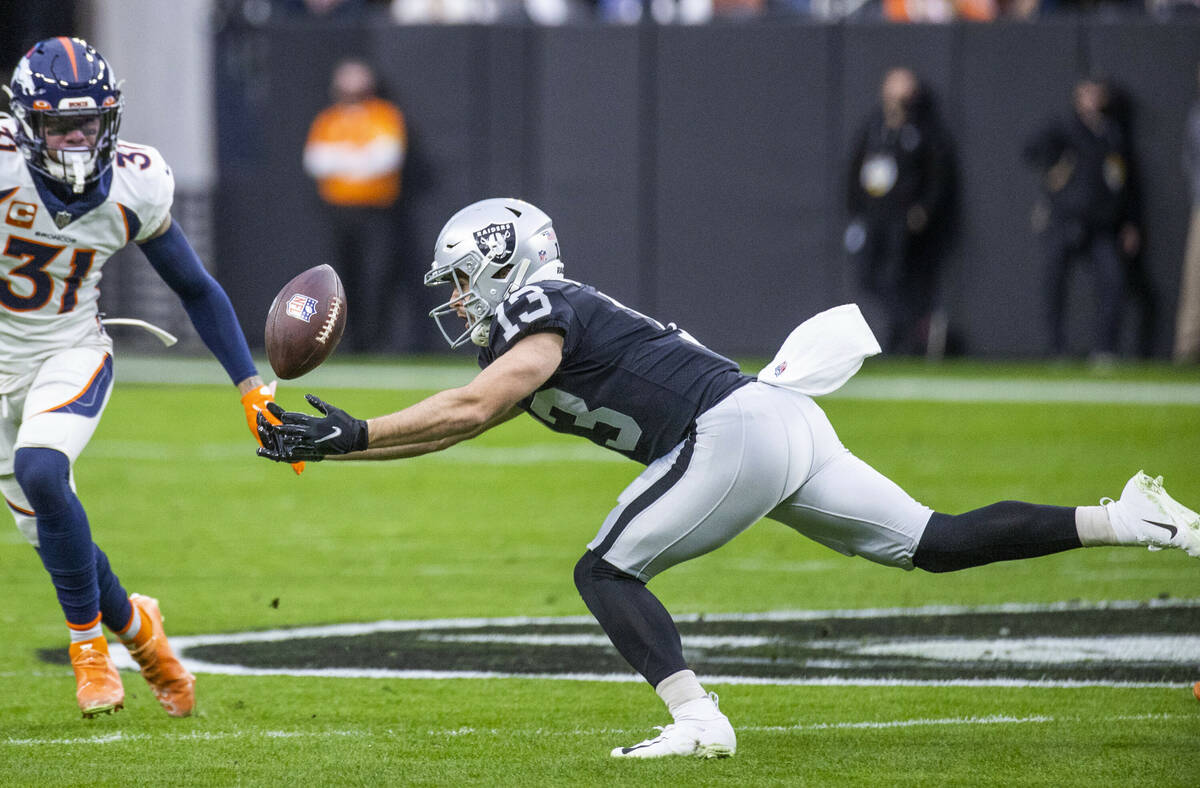 Raiders wide receiver Hunter Renfrow (13) extends for a catch as Denver Broncos free safety Jus ...