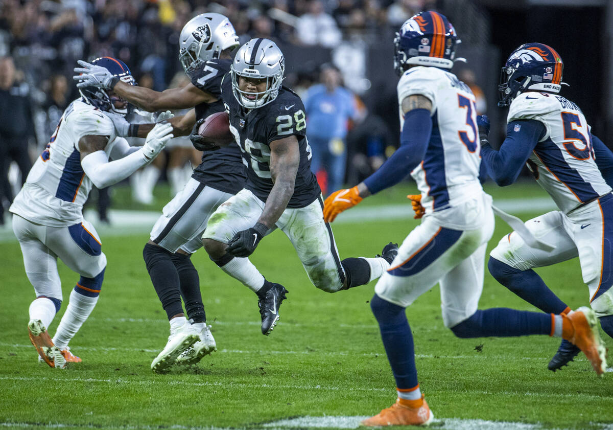 Raiders running back Josh Jacobs (28) catches some air after breaking free for a long run versu ...