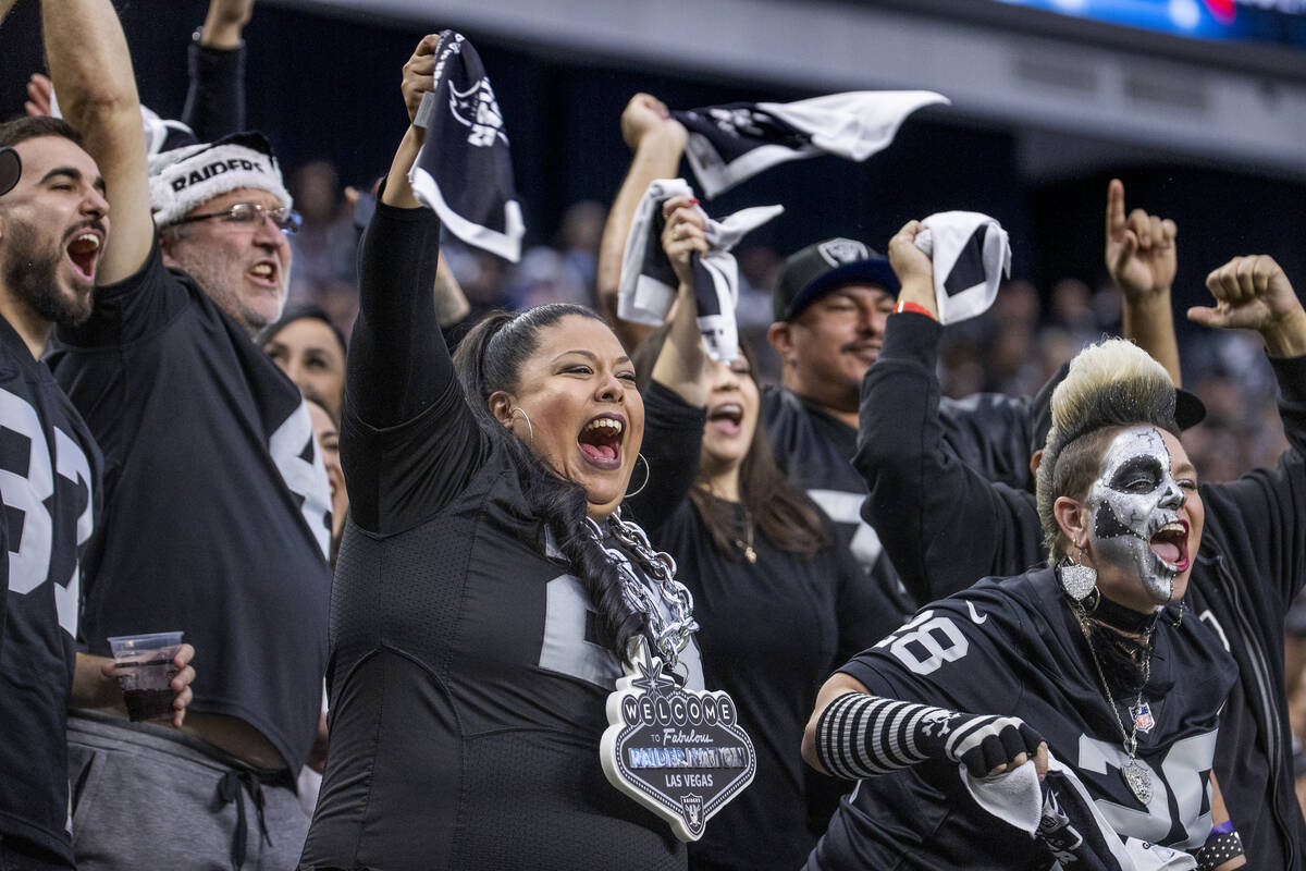 Raiders fans celebrate a score versus the Denver Broncos during the first half of their NFL gam ...