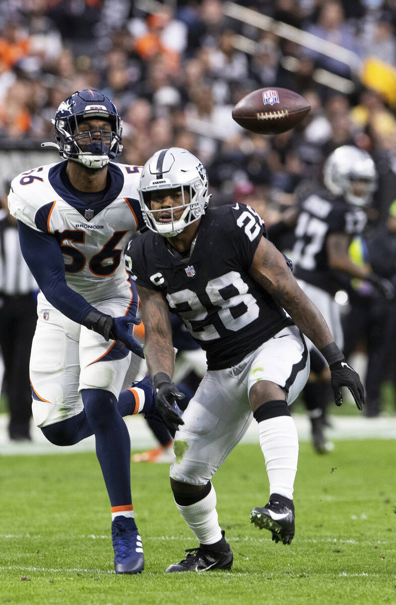Raiders running back Josh Jacobs (28) tries to make a reception with Denver Broncos inside line ...