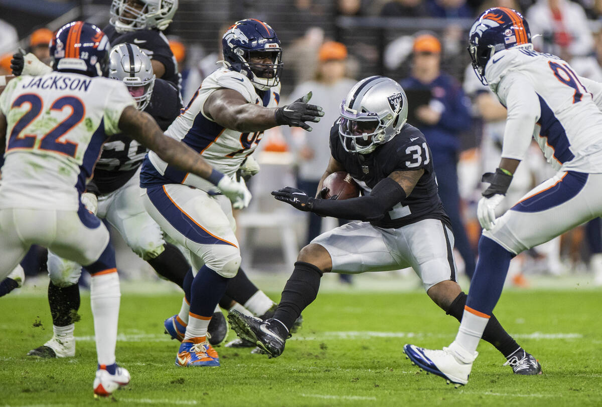 Raiders running back Peyton Barber (31) runs past Denver Broncos outside linebacker Stephen Wea ...