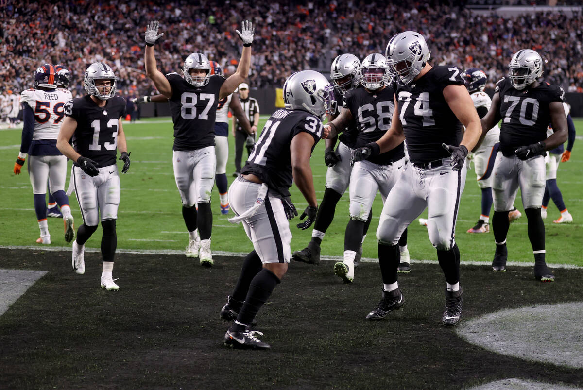 Raiders players celebrate a touchdown by Raiders running back Peyton Barber (31) against the De ...