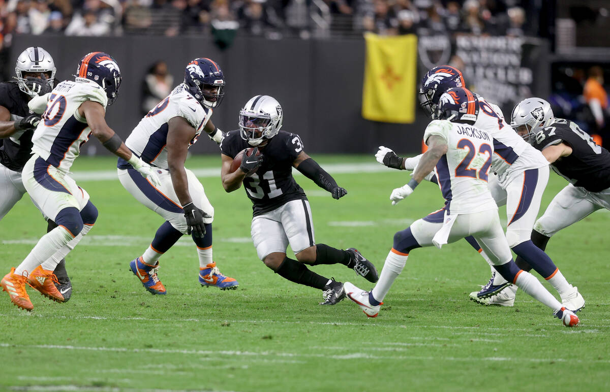 Raiders running back Peyton Barber (31) moves the ball against the Denver Broncos in the third ...