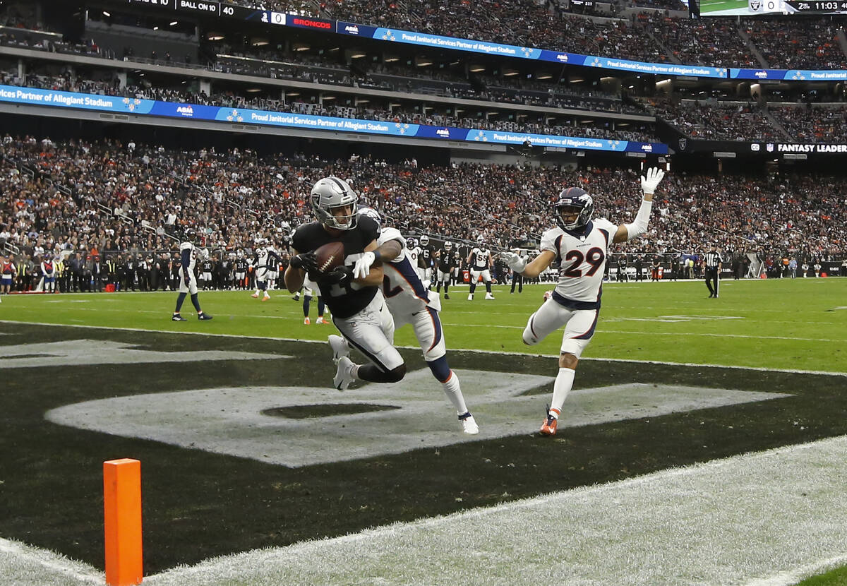 Raiders wide receiver Hunter Renfrow (13) scores a touchdown under pressure from Denver Broncos ...