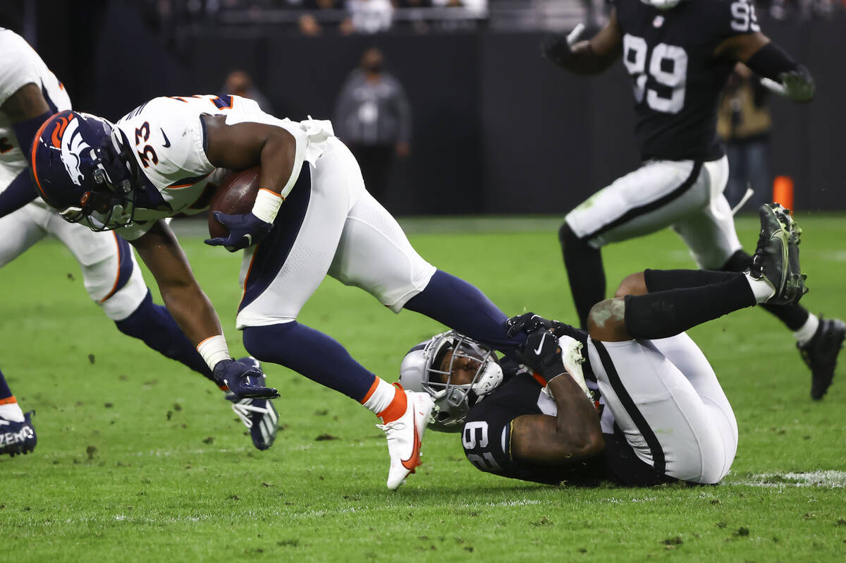 Denver Broncos running back Javonte Williams (33) gets tripped up by Raiders cornerback Casey H ...