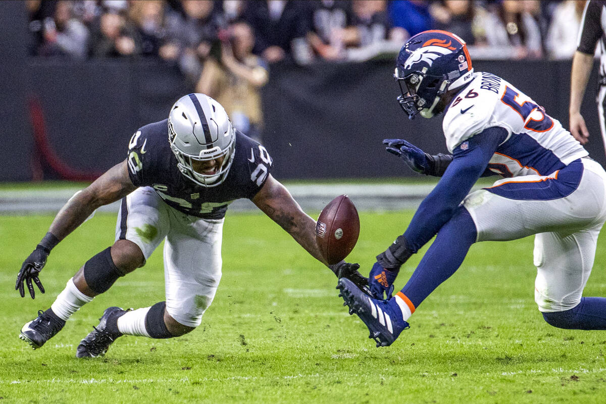 Raiders running back Josh Jacobs (28) fumbles the ball as Denver Broncos inside linebacker Baro ...