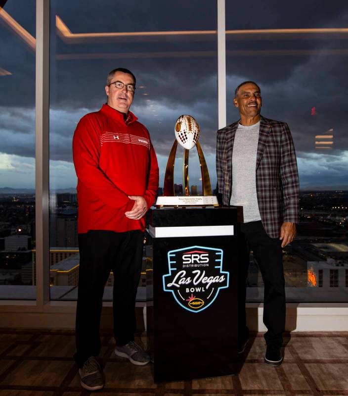 Wisconsin coach Paul Chryst, left, and Arizona State coach Herm Edwards pose with the trophy du ...