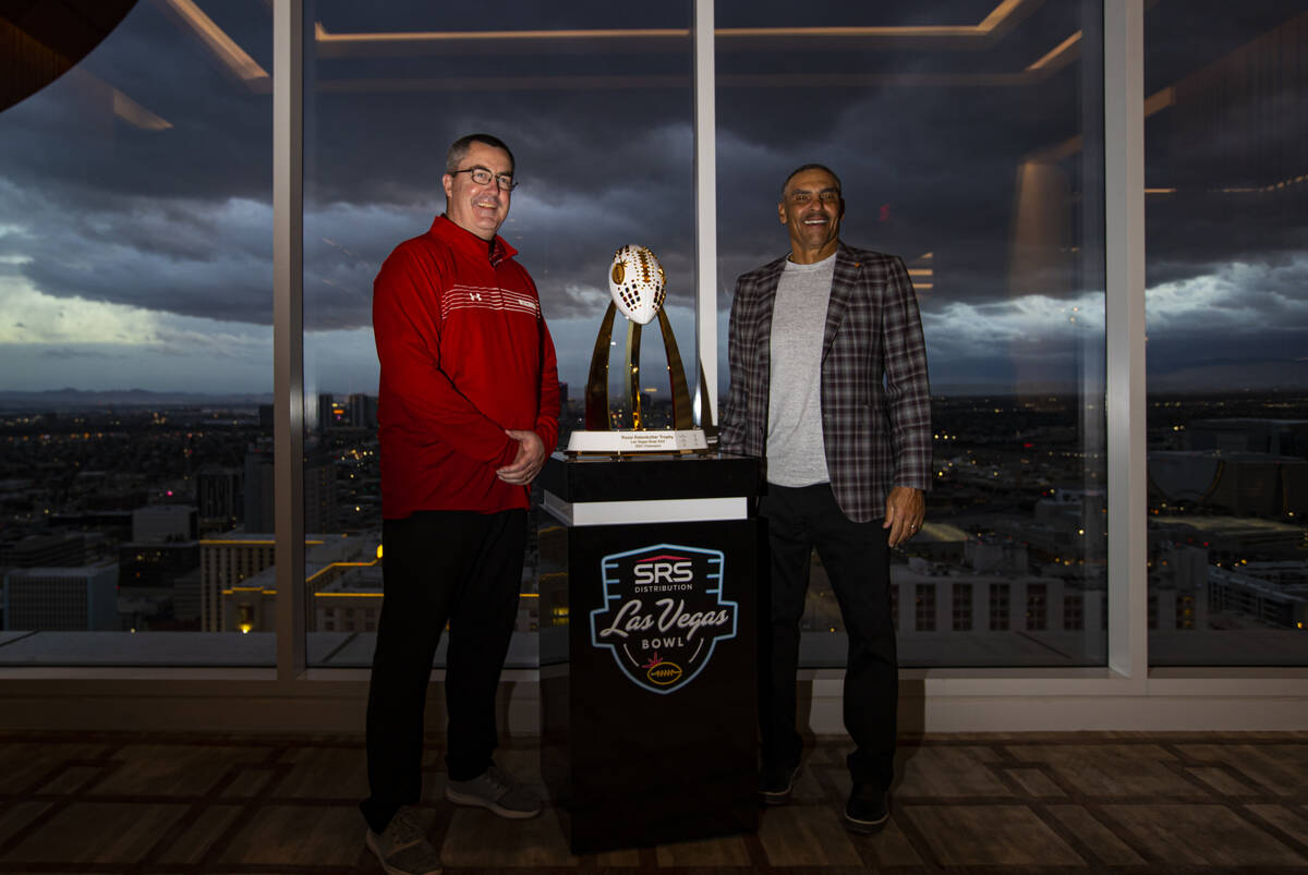 Wisconsin coach Paul Chryst, left, and Arizona State coach Herm Edwards pose with the trophy du ...