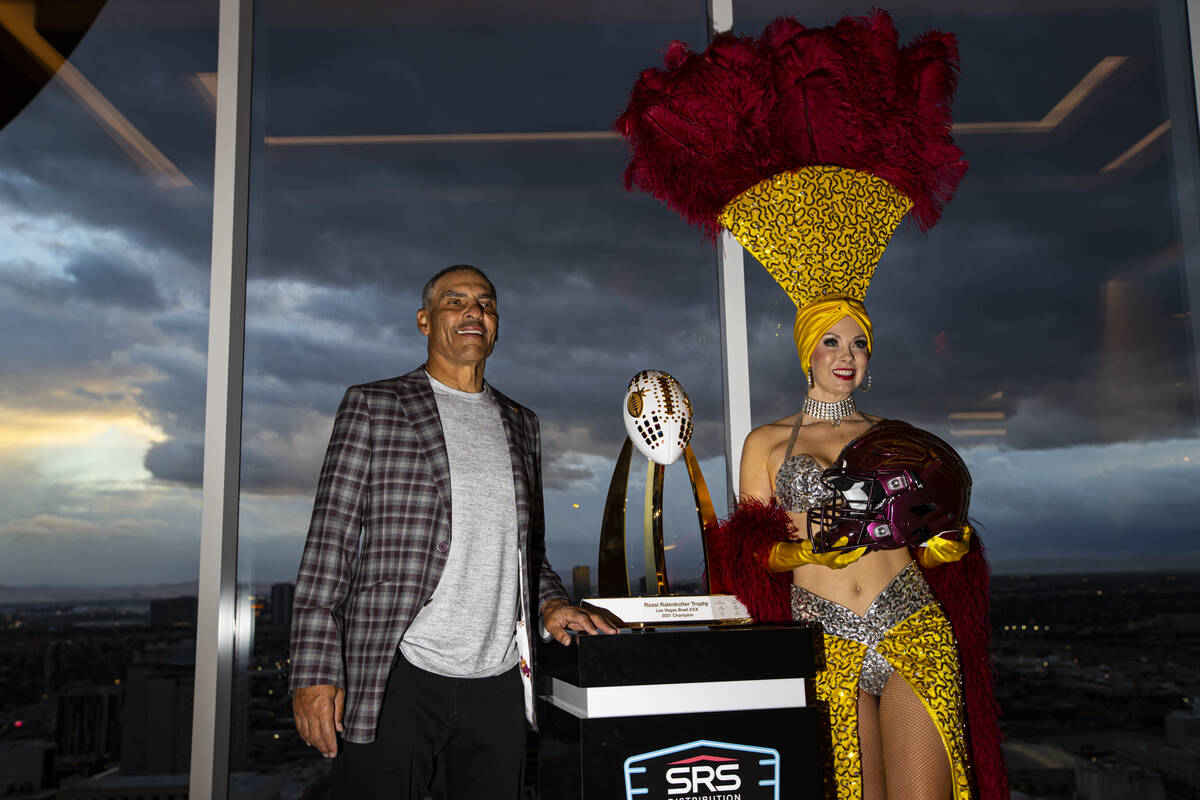 Arizona State football coach Herm Edwards, left, poses with showgirl Jennifer Autry during a me ...