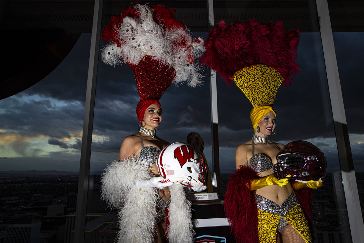 Showgirls Porsha Revesz, left, and Jennifer Autry hold helmets representing Wisconsin and Arizo ...