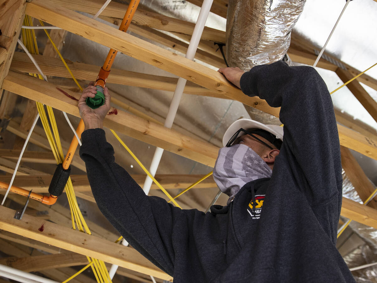 Julian Hernandez of B2C Mechanical works on a sprinkler system at Lennar at Heritage at Stonebr ...