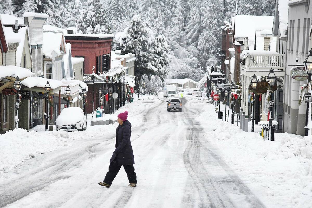 While snowfall was picturesque in places such as along Broad Street in Nevada City, Calif., it ...