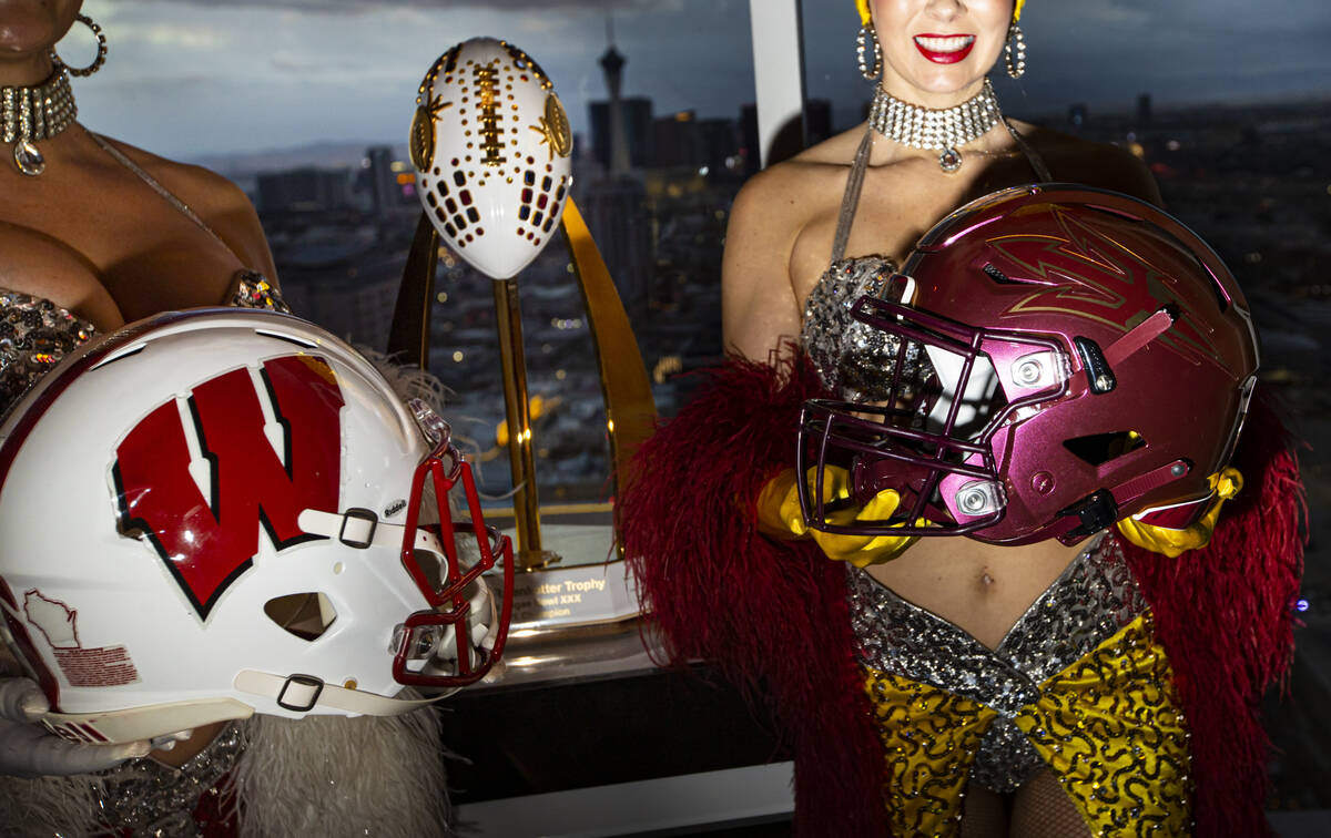 Showgirls Porsha Revesz, left, and Jennifer Autry hold helmets representing Wisconsin and Arizo ...