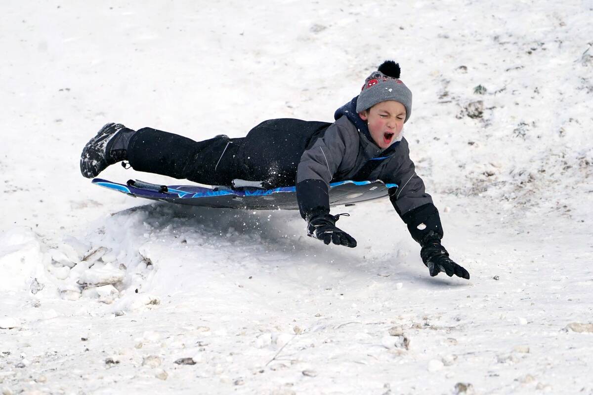 Titus Gonzalez goes airborne after hitting a bump while sledding where nearly a foot of snow fe ...