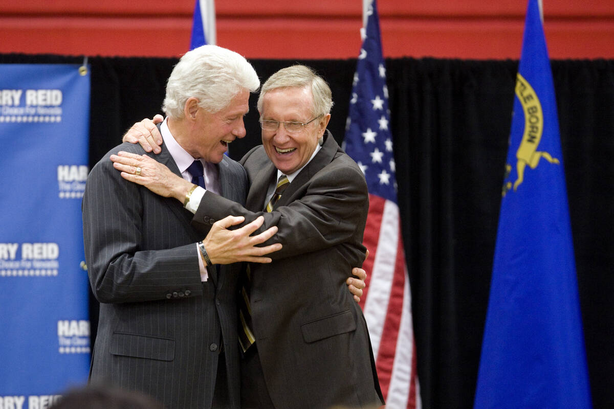 Former President Bill Clinton, left, shares a laughter  and a hug with U.S. Senator Harry Reid, D-N ...