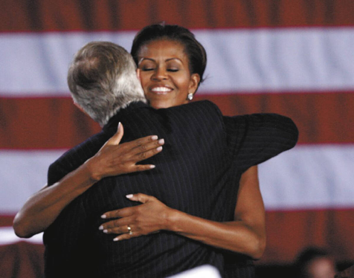 First Lady Michelle Obama hugs U.S. Senator Harry Reid, D-Nev., astatine  Canyon Springs High School one  ...