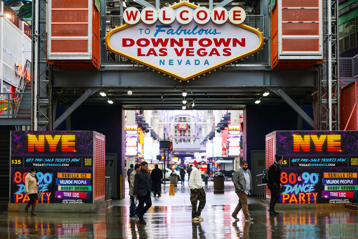 Visitors walk through the rain at the Fremont Street Experience in Downtown Las Vegas, Tuesday, ...