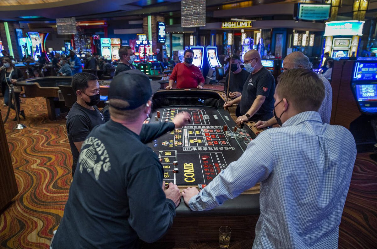 A guest tosses the dice during a game of Craps at Red Rock Casino on Tuesday, Dec. 26, 2021, in ...